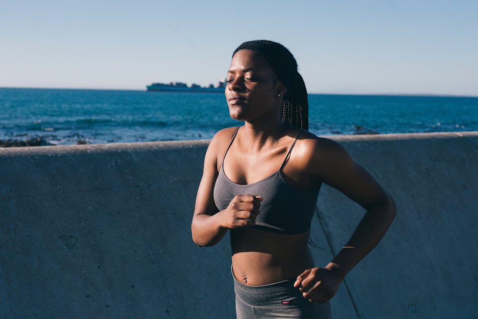 A young woman in activewear jogging along the ocean, embracing a healthy lifestyle